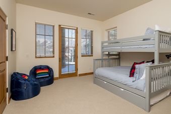A bedroom with a bunk bed and two bean bag chairs.