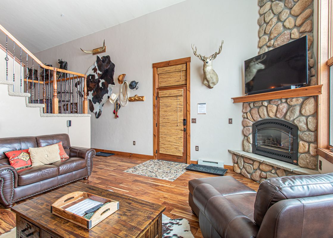 A living room with a fireplace and a large leather sofa.