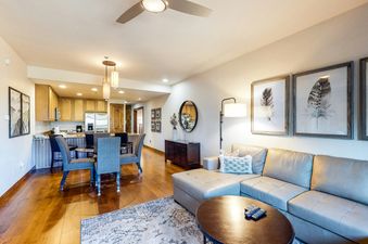 A living room with a couch, a coffee table, and a dining table.