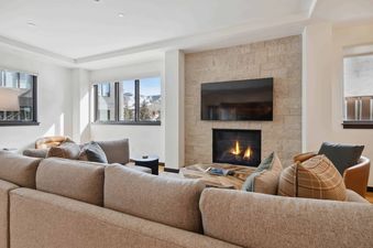 The Lion W302 living room features a large sectional sofa, fireplace, and a stunning view of the mountains.