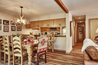 Dining area with an antler chandelier and view of the kitchen in Rendezvous D1.