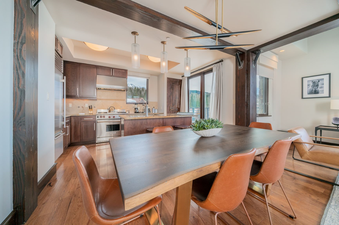 Dining table with six chairs in a modern kitchen and living room.