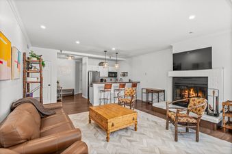 A cozy living room with a fireplace, a leather couch, and a coffee table.