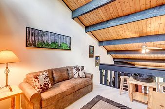 A living room with a couch, a side table with a lamp, and a wooden coffee table with a basket.
