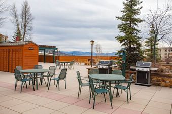 Outdoor patio of Kutuk 108 featuring dining tables, BBQ grills, and a mountain view.