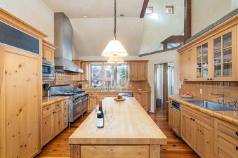 A kitchen with wood cabinets and a large island.