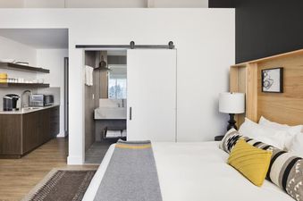 Modern bedroom and kitchenette area inside the Gravity Haus JH Premium King Suite.