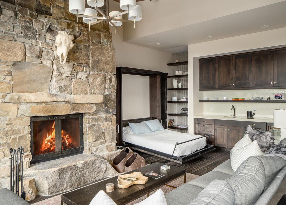 A spacious living room with a fireplace and a Murphy bed in Moonlight Basin 4B Lodgeside.