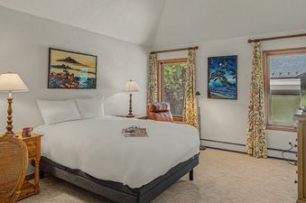 Inviting bedroom at Wild Iris Lodge with a queen bed, wooden furniture, and scenic window views.