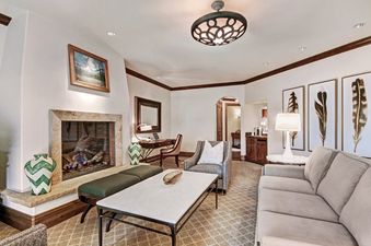 Elegantly furnished living room with a fireplace in the Arrabelle King Suite.