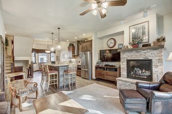 A living room with a fireplace, a large sectional couch, and a coffee table.