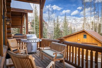 The beautiful deck at Wild Bear Haven features comfortable seating and a grill with mountain views.