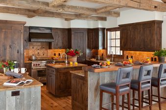 Gourmet kitchen in Shooting Star Cabin 04 featuring dark wood cabinetry, exposed ceiling beams, a central island, and a breakfast bar with seating.