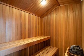 An image of the sauna at Snowblaze A33, featuring a comfortable wooden interior with tiered benches and a heating unit.