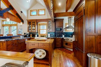 The kitchen in Quittin Time on Woodside features wood floors, cabinets, and an island.