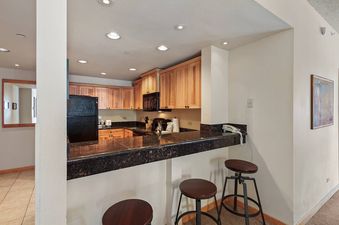A kitchen with a breakfast bar that has three stools