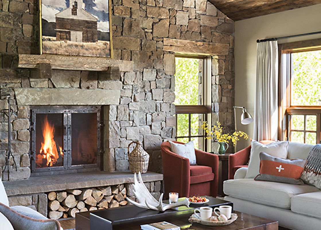 Cozy living room with a large stone fireplace and warm wood ceilings at Shooting Star Cabin 02.