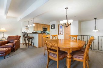 A dining room with a wooden table and chairs in a vacation rental.
