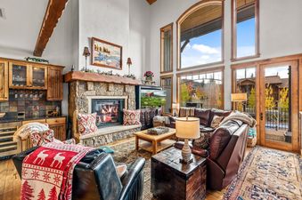 Comfortable living room at Cimarron 4 with stone fireplace and large windows with mountain views.