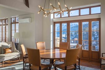 A dining room with a large window that overlooks a snowy mountain landscape.