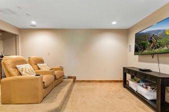 The Fairway Serenity offers a comfortable and inviting entertainment space with two plush recliners, a flat-screen TV, and a stylish console table.