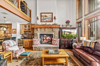 Cozy living room with stone fireplace and plush leather seating at Cimarron 4.