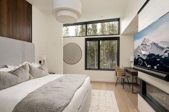 Moonlight Basin 5 Thistle Way bedroom with a king-sized bed, large windows, and a fireplace.