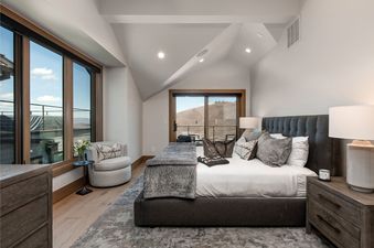 A luxurious bedroom at Abode at Powder King with a large bed, stylish decor, and expansive windows offering mountain views.