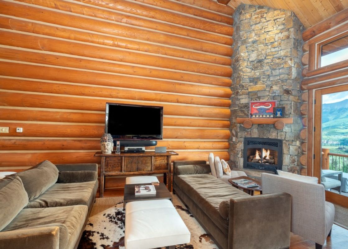 The living room features a stone fireplace and comfortable couches at Townhomes on the Creek 117.