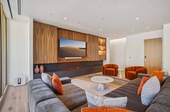 A modern and inviting living room in Founders Place 2302, featuring a fireplace, a large TV, comfortable seating, and stylish decor.