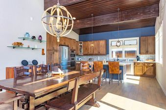 Spacious dining and kitchen area with wood accents and a blue feature wall at Peak View Paradise.