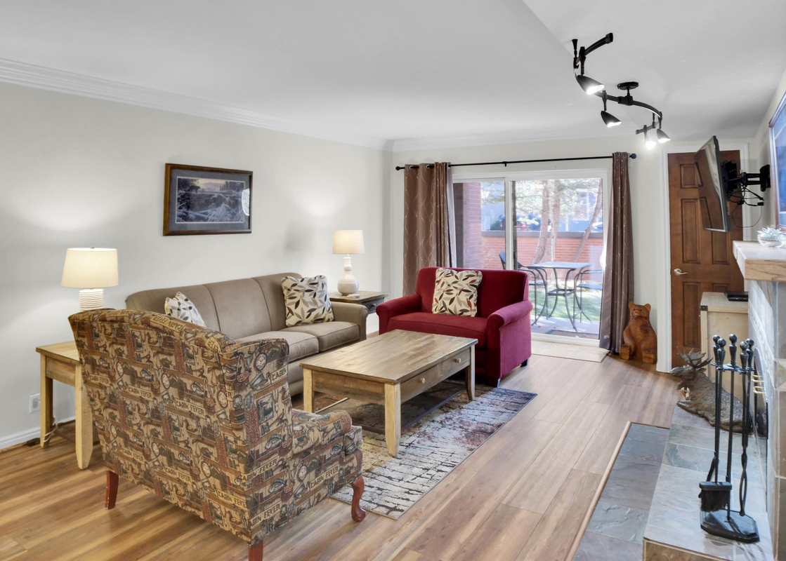 Park Station 113 has an open concept living area with natural light pouring in from sliding doors and white walls.
