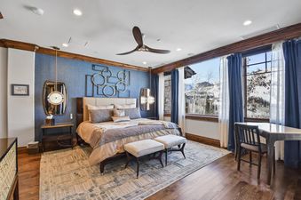 The master bedroom at Silver Strike Lodge 201 features a large bed, elegant decor, and panoramic views of a snowy mountain landscape.