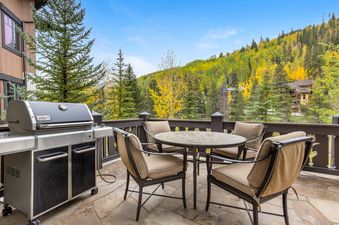 The outdoor balcony at Gore Place with a grill, dining table, and mountain views.