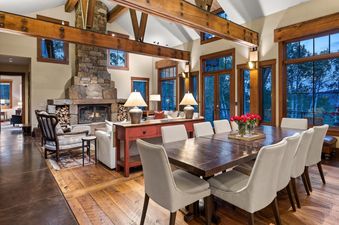 A Creekside Lodge features a large dining table with chairs in the center of the room.