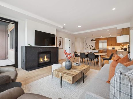 An open concept living area with a fireplace, dining table, and kitchen.