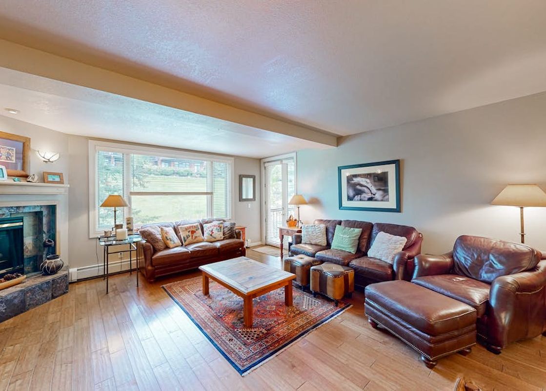 A comfortable living area in Meadows Sheffield 3 with leather sofas, a coffee table, and a cozy fireplace.