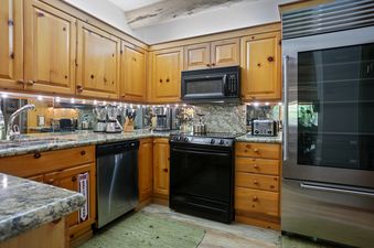 Pine Inn 09 kitchen features stainless steel appliances, a microwave, an oven, a dishwasher, and a refrigerator.