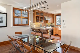 Dining area with a glass table and kitchen at Ascent at Aspen Ridge.