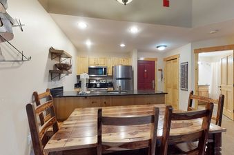 A dining table with chairs next to a kitchen in Taylors Crossing 109.