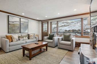 The inviting living room at Lodge Tower 678 features comfortable seating and a stunning mountain view.