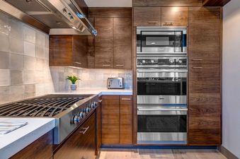 The kitchen in Abode at Little Belle 3 features stainless steel appliances, custom cabinetry, and modern finishes.