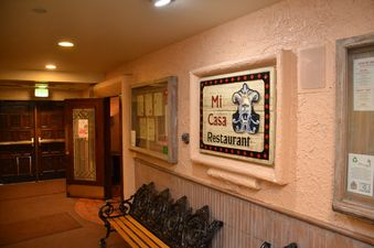 A sign reading "Mi Casa Restaurant" hanging on a wall inside a restaurant.
