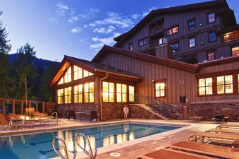 Outdoor pool and lodge exterior at dusk.