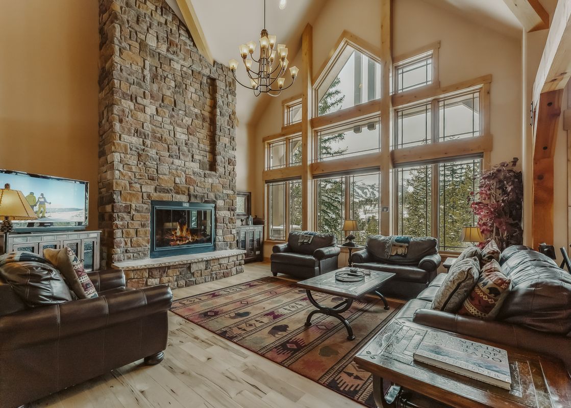 The living room in Mont Vista Chateau features a stone fireplace and large windows.