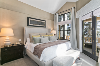 The master bedroom in the Lodges at Deer Valley 2 Bedroom Suite features a king-size bed, plush bedding, and large windows with views of the mountain.