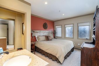 Bedroom in Shirana 1 and 7 featuring a bed, bedside table, and rustic wood headboard.