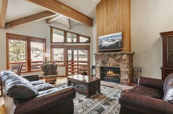 Enclave 11 living room with stone fireplace and leather furniture.