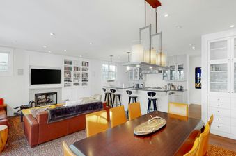 The open-concept living space at Depot 417 features a cozy fireplace and elegant dining area.