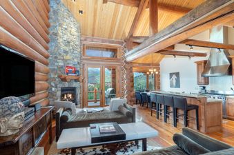 The living area of Townhomes on the Creek 117 features a stone fireplace and natural light.